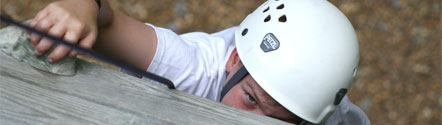 A boy climbs to the top of the climbing tower
